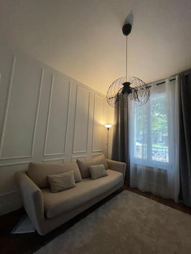 een woonkamer met een bank en een raam bij Luxury modern Appartment Paris in Maisons-Alfort