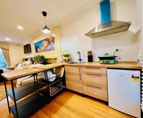 een keuken met een houten aanrechtblad en een koelkast bij Cozy Self Contained Studio with Seperate Spacious Living room -Just a Stone's Throw from Newly Renovated Knox Westfield in East Melbourne in Wantirna South