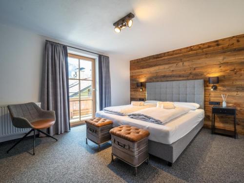 a bedroom with a bed and a chair and a window at Fernblick in Kirchberg in Tirol