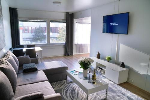 un soggiorno con divano e TV a parete di 4-roomIIPerfect locationIICenter a Oulu