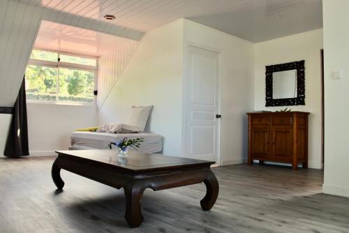 a living room with a coffee table and a bed at Tekauhivai Lodge in Uturoa