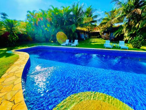 una piscina en un patio con sillas y árboles en Pousada Terra do Mar, en Búzios