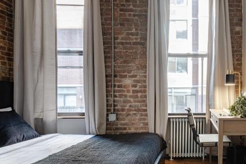 - une chambre avec un lit et un mur en briques dans l'établissement Apartment 253: Chelsea, à New York