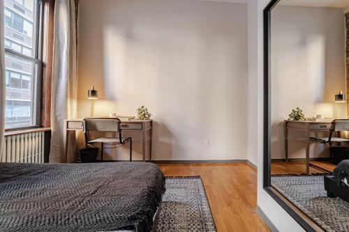 a bedroom with a bed and a desk and a mirror at Apartment 253: Chelsea in New York