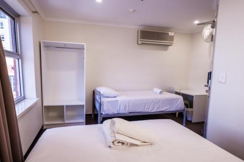 a hospital room with two beds and a window at YHA Adelaide Central in Adelaide