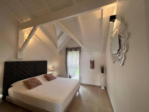 a bedroom with a large white bed and a window at KANOA LODGE piscine et vue mer in Saint-Claude