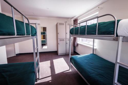 Adelaide的住宿－YHA Adelaide Central，客房设有两张双层床和一扇窗户。