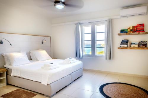 um quarto com uma cama branca e uma janela em Oceanfront Penthouse on the beach Bellevue 10 em Kralendijk