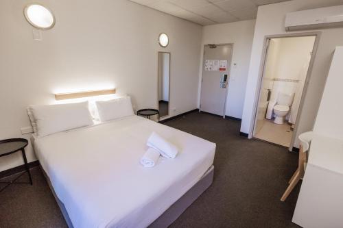 - une chambre avec un grand lit blanc et 2 toilettes dans l'établissement YHA Adelaide Central, à Adélaïde
