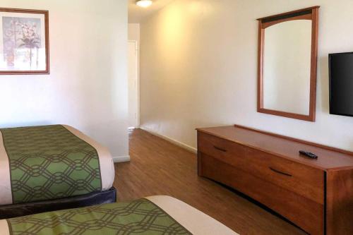 um quarto com duas camas e uma cómoda com uma televisão em Garden Inn & Suites Oakland Airport em Oakland