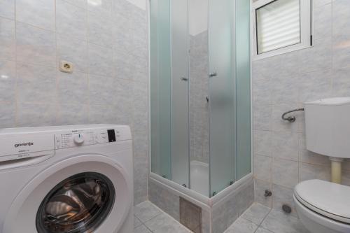 a bathroom with a washing machine and a toilet at Apartments with parking space Marusici, Omis - 1131 in Mimice