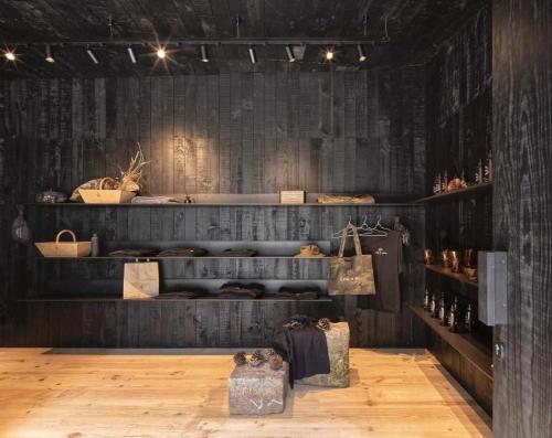 a room with a wooden floor and shelves with bags at A Leira 116 Cabañas de diseño in Sarria