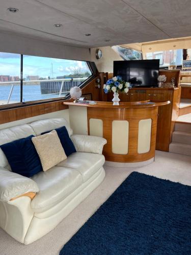 a living room with a couch and a tv on a boat at SUPERYACHT ON TOWN QUAY MARINA, SOUTHAMPTON - Very close to city centre and cruise terminals - free parking included in Southampton