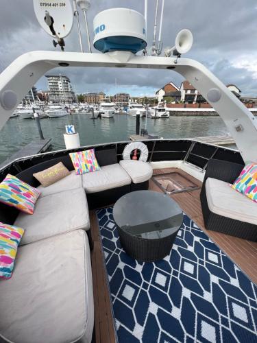 a boat with couches and a table on the deck at SUPERYACHT ON 5 STAR OCEAN VILLAGE MARINA, SOUTHAMPTON - minutes away from city centre and cruise terminals - free parking included in Southampton
