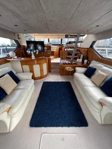 ein großes Wohnzimmer in einem Boot mit Sofas und einem Teppich in der Unterkunft SUPERYACHT ON 5 STAR OCEAN VILLAGE MARINA, SOUTHAMPTON - minutes away from city centre and cruise terminals - free parking included in Southampton