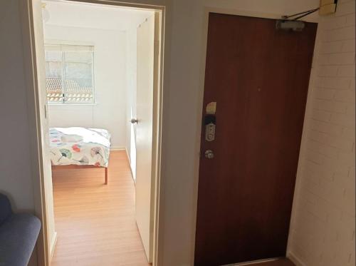 Una puerta que conduce a un dormitorio con una cama en una habitación en Private Room in a 3-Bedroom Apartment-3 en Canberra