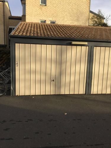 a wooden garage with a building next to a street at Dana-Private Room in a 3-Bedroom Apartment-3 in Canberra