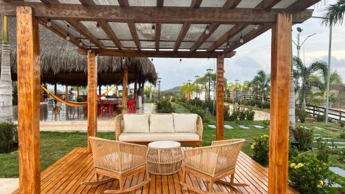 a wooden pergola with a couch and chairs on a deck at BRISAS DE BARU in Ararca