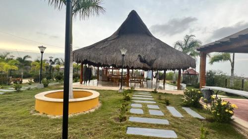 a pavilion with a large straw umbrella in a park at BRISAS DE BARU in Ararca