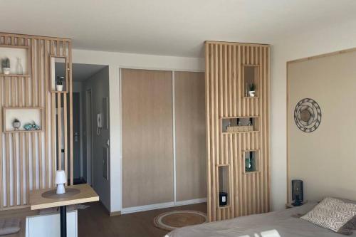 a bedroom with a bed and a table and a clock at F1 standing vue mer Anse Vata in Noumea