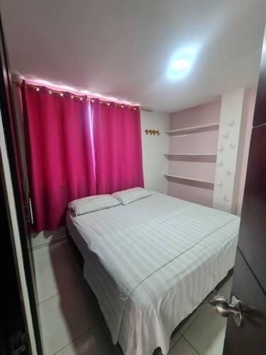 Un dormitorio con una cortina rosa y una cama en Lindo departamento en conjunto multifamiliar, en Barranquilla
