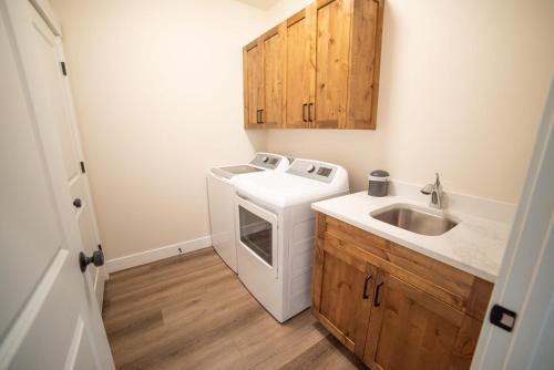 a small kitchen with a washing machine and a sink at Searchers Hideaway at Kabab - New West Properties in Kanab