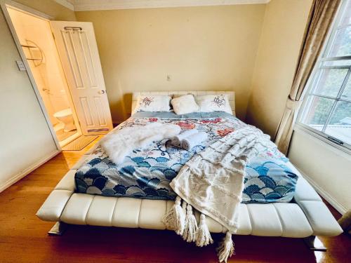 una camera da letto con un letto con una coperta sopra di Cozy 5BR Home with Pool table and King bed a Wantirna South