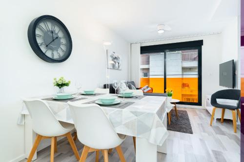 a dining room with a table and a clock on the wall at D.O.M.A. Residencial Alegria in Torrevieja