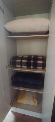 a closet with shelves with a pillow and towels at Cabaña Pelulandia in Playa Verde