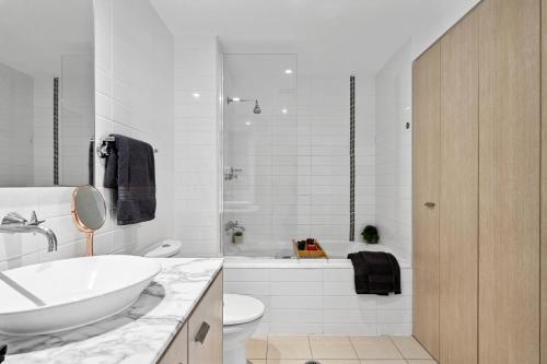 a bathroom with a sink and a toilet and a tub at Luxury Stays Varsity-Robina-Bond in Gold Coast