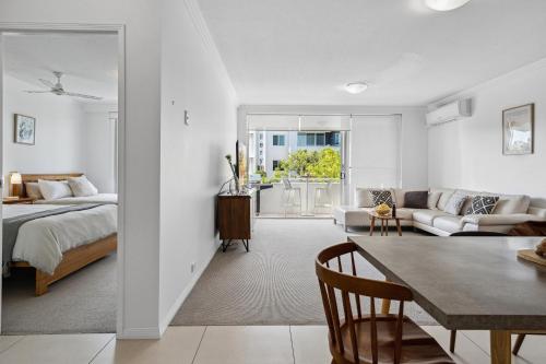 a bedroom with a bed and a living room with a table at Luxury Stays Varsity-Robina-Bond in Gold Coast