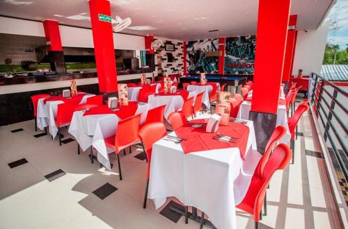 a restaurant with red and white tables and chairs at Bora Bora Adults only in Melgar