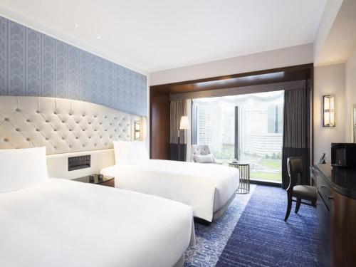 a hotel room with two beds and a window at Hilton Yokohama in Yokohama