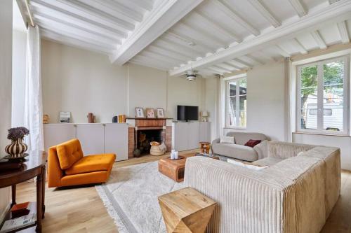 un salon avec deux canapés et une cheminée dans l'établissement Maison Maliott, à Colleville-sur-Mer