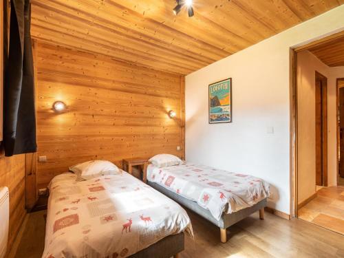two beds in a room with wooden walls at Cosy apartment in Tignes with garden in Tignes