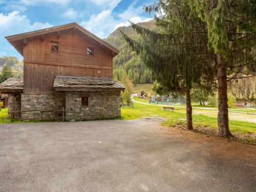 ein großes Holzgebäude mit einem Baum daneben in der Unterkunft Lake view chalet in Tignes close to ski area in Tignes