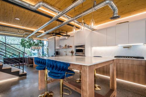 a kitchen with a large wooden table and blue chairs at Sunrise View - Spa-Inspired Guestroom, Halifax Rooftop Home in Halifax