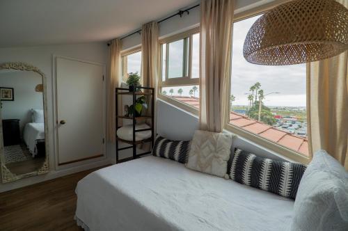 1 dormitorio con 1 cama y ventana grande en Beach Shack en Huntington Beach