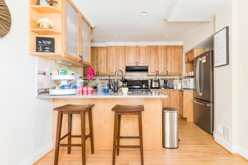 a kitchen with wooden cabinets and stainless steel appliances at Classic Brick House 4BR 3BA Perfect for Families Near DC in Arlington