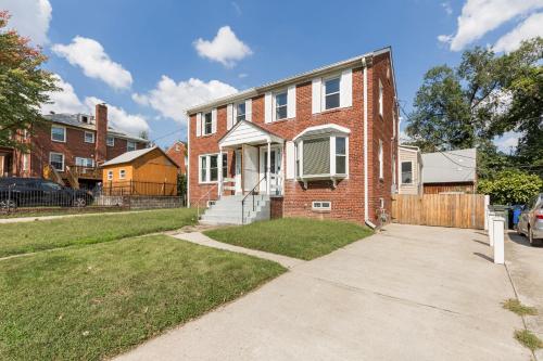 a brick house with a gate and a driveway at Classic Brick House 4BR 3BA Perfect for Families Near DC in Arlington