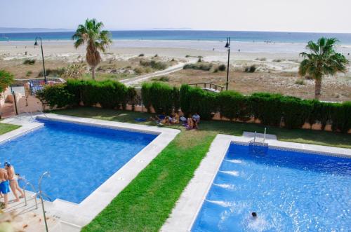 a view of a swimming pool and the beach at Apartamento Los Lances II in Tarifa