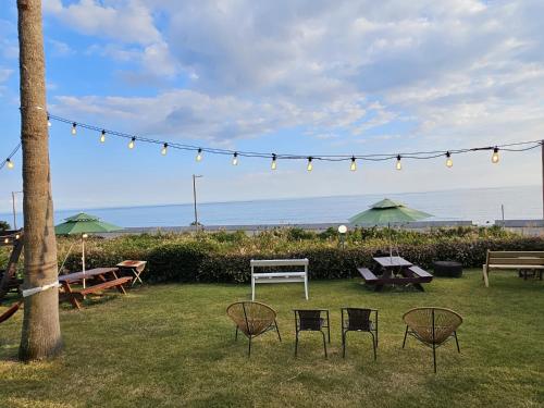 a group of chairs and tables in a yard with lights at Old Man And Sea in Seogwipo