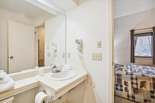 y baño con lavabo y espejo. en Cedarbrook Deluxe Two Bedroom Suite with outdoor heated pool 20910, en Killington