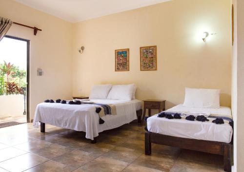 a bedroom with two beds with white sheets at hotel stella maris tulum in Tulum