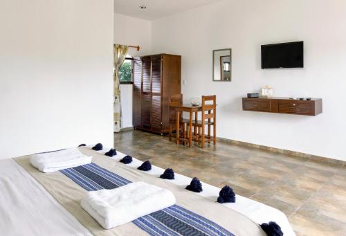 1 dormitorio con 1 cama con toallas y mesa en hotel stella maris tulum en Tulum