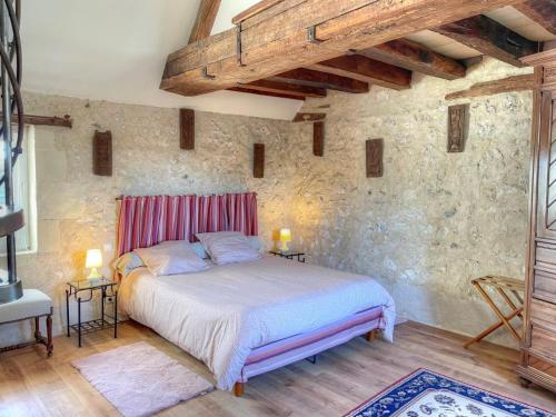 um quarto com uma cama numa parede de pedra em Gîte Villandry, 4 pièces, 7 personnes - FR-1-381-471 em Villandry