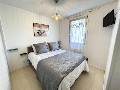 ein Schlafzimmer mit einem Bett und einem Fernseher darin in der Unterkunft Appartement à 50m plage avec terrasse et jardin - FR-1-361-14 in Jullouville-les-Pins