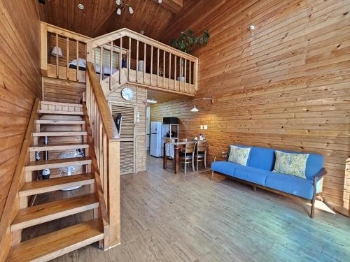 a living room with a blue couch and a wooden wall at Old Man And Sea in Seogwipo