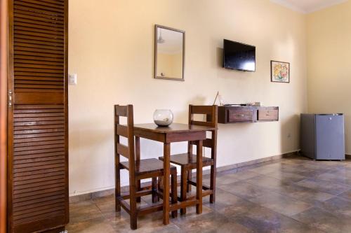 a dining room with a table and chairs and a television at hotel stella maris tulum in Tulum