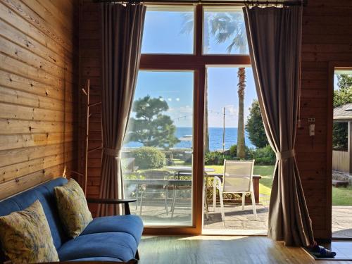 a living room with a couch and a large window at Old Man And Sea in Seogwipo